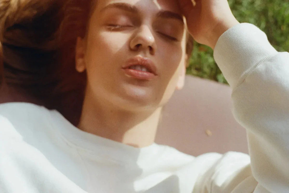 Woman with hand on her head in bright sunlight
