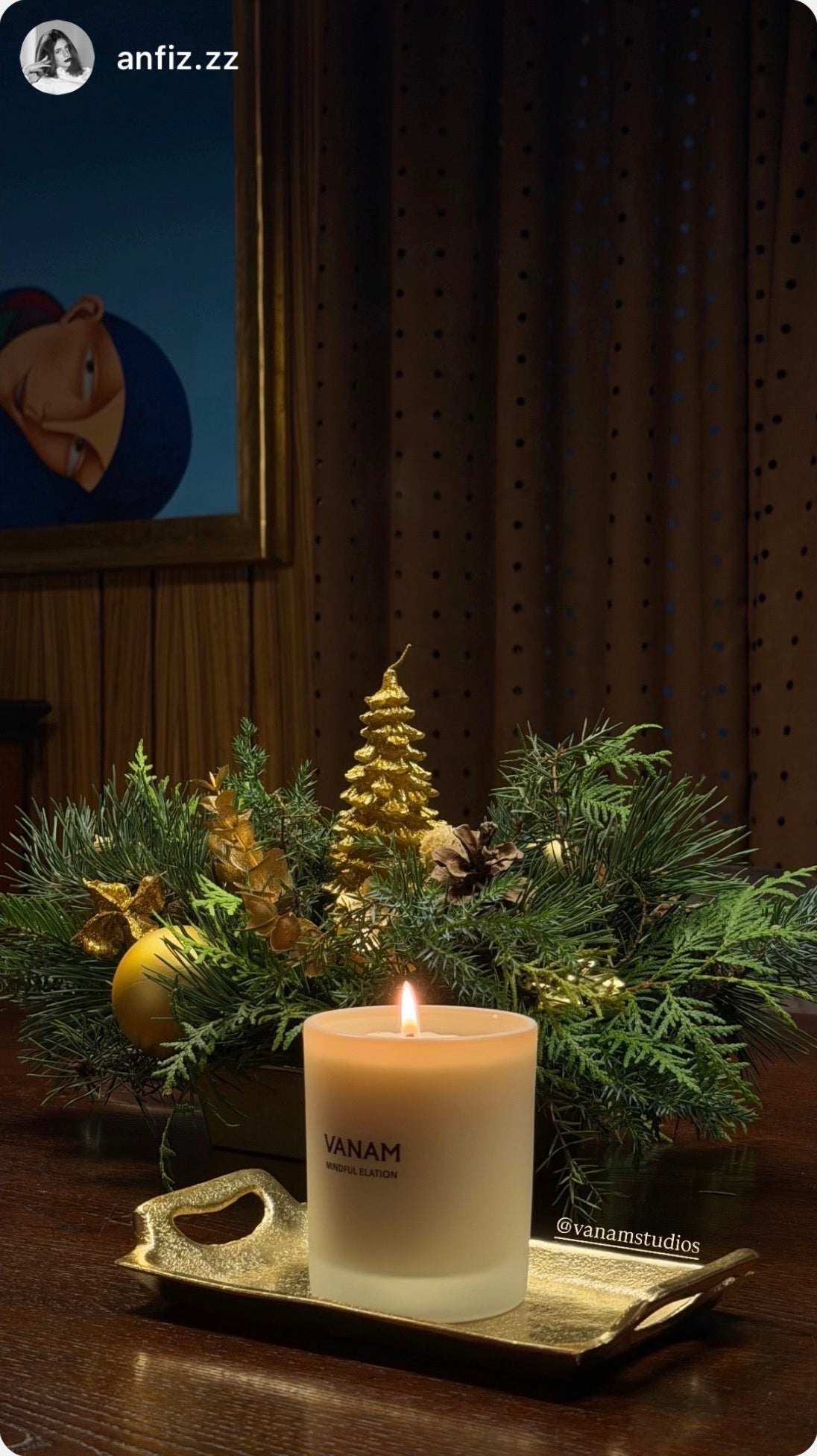 Vanam beeswax candle burning on a gold tray surrounded by festive Christmas decorations