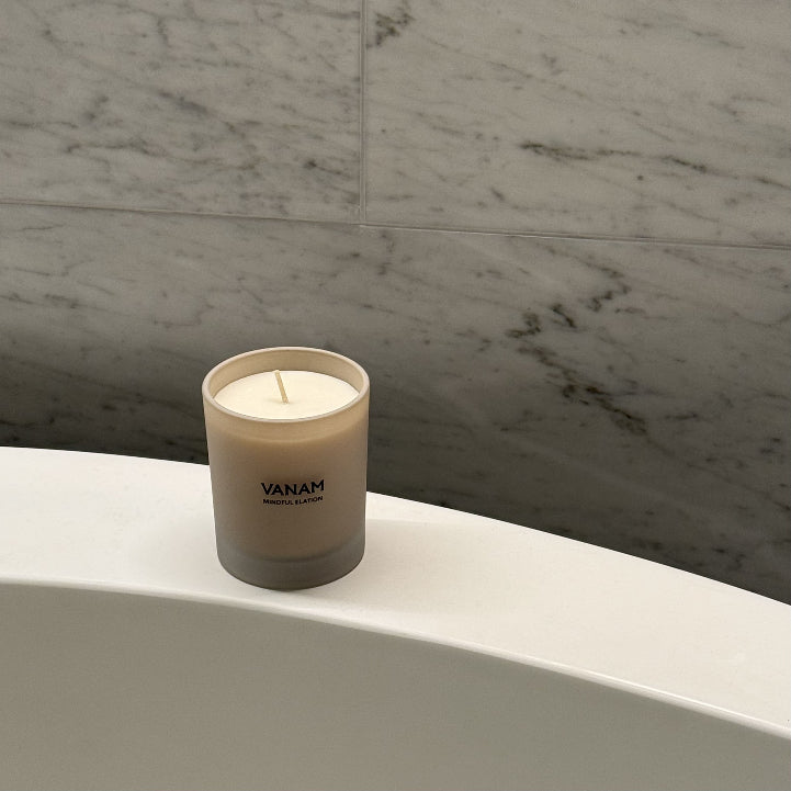 MINDFUL ELATION beeswax candle resting on a freestanding bath — Vanam luxury home fragrance